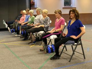 Montana State University Extension Agent Jane Wolery, near right, leads class participants in seated leg lifts at a session of the StrongPeople class last fall in the Choteau Baptist Church fellowship hall.